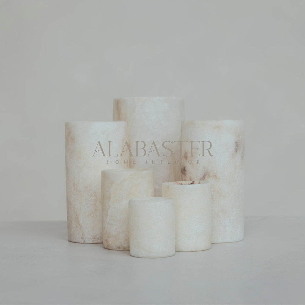 Cilinder-vormige alabaster waxinelichthouder met sfeervol licht.