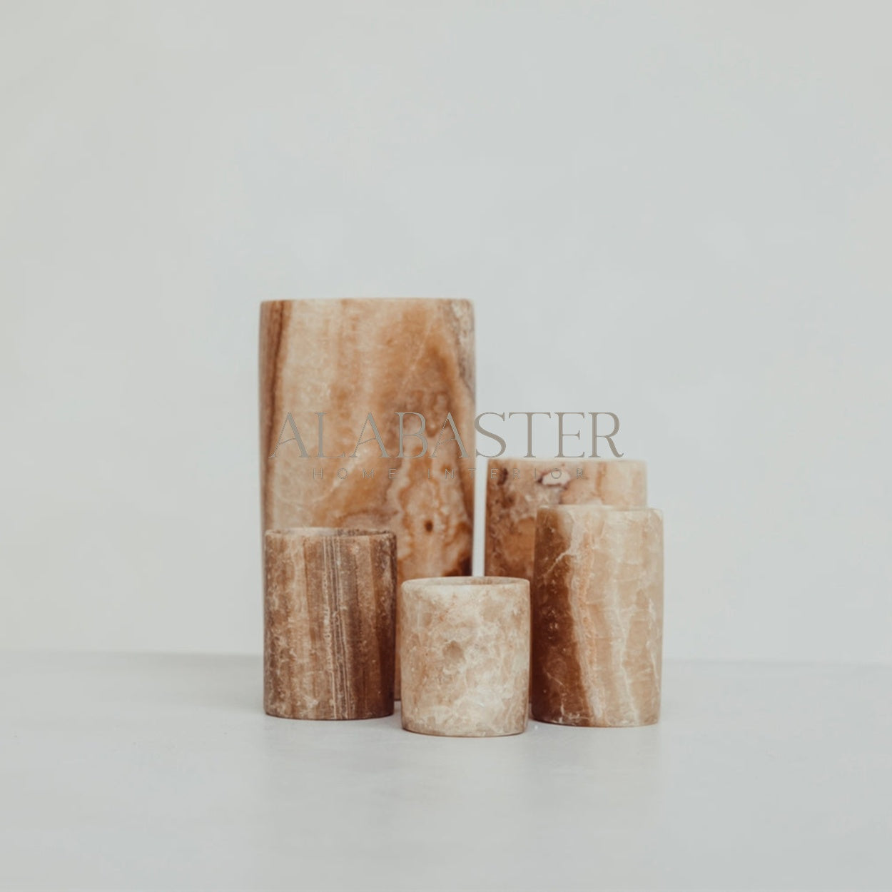 Cilinder-vormige alabaster waxinelichthouder met sfeervol licht.