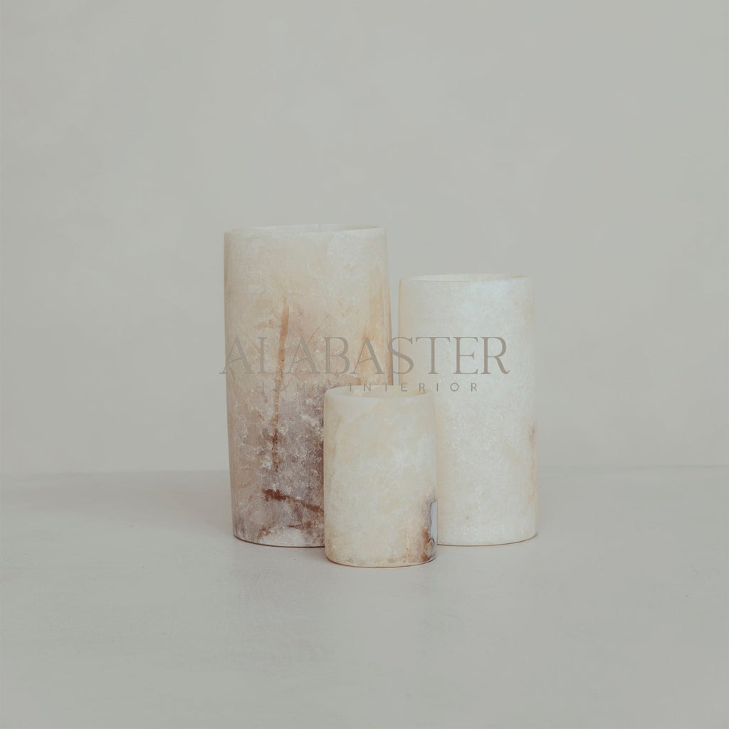 Cilinder-vormige alabaster waxinelichthouder met sfeervol licht.