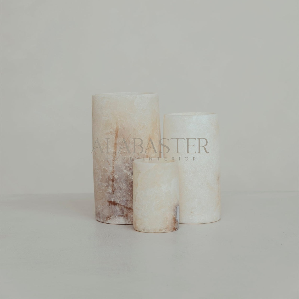 Cilinder-vormige alabaster waxinelichthouder met sfeervol licht.