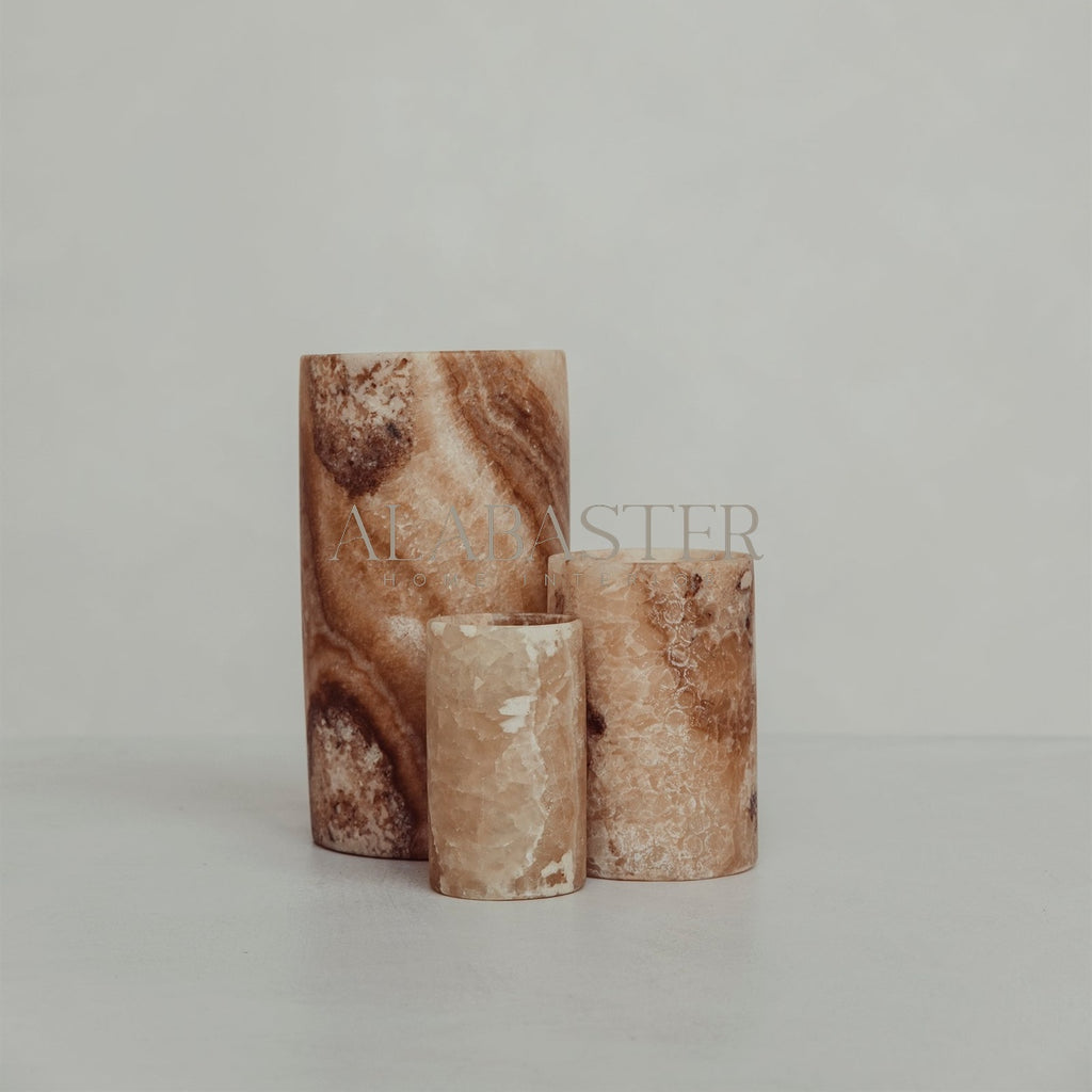 Cilinder-vormige alabaster waxinelichthouder met sfeervol licht.