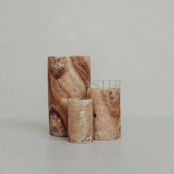 Cylindrisk alabaster-fyrfadsstage med stemningsfuldt lys.